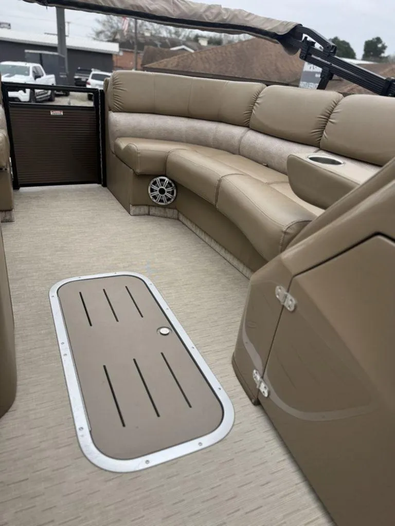 Slide: The Image of 2016 Bennington 2575 QCW I/O boat interior with beige seating and flooring. - 8