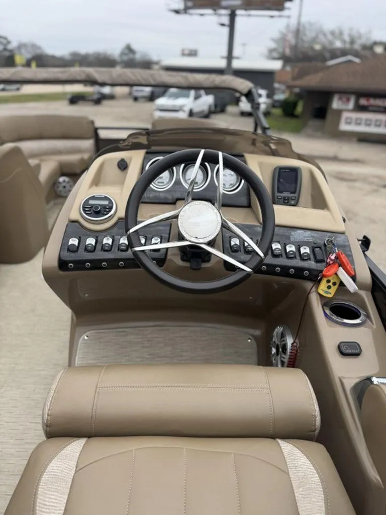 Slide: The Image of 2016 Bennington 2575 QCW I/O boat dashboard with steering wheel and controls. - 9