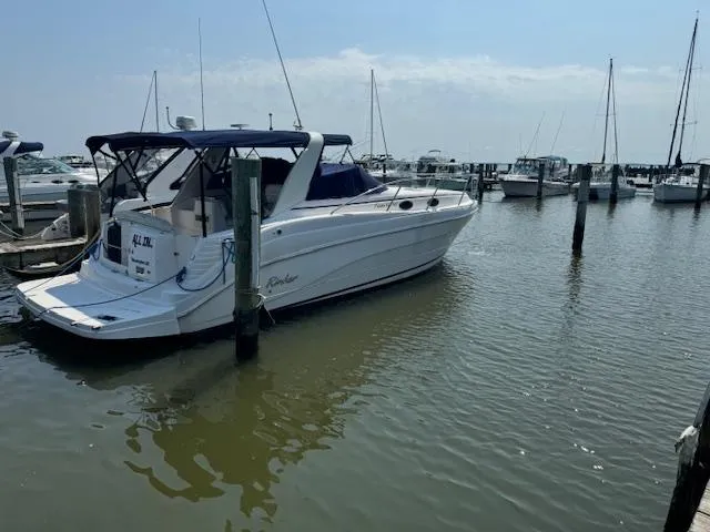 Slide: The Image of 2004 Rinker Fiesta Vee 342 docked in a marina, surrounded by sailboats. - 2