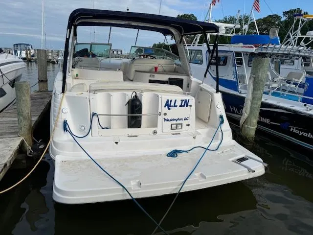 Slide: The Image of 2004 Rinker Fiesta Vee 342 boat docked at marina, rear view with "All In" nameplate. - 8