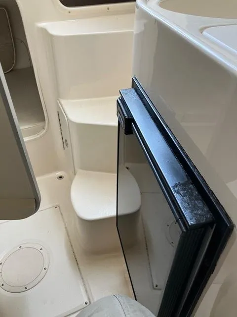 Slide: The Image of Interior view of 2003 Grady-White Sailfish 282 boat, featuring steps and a compact fridge. - 11