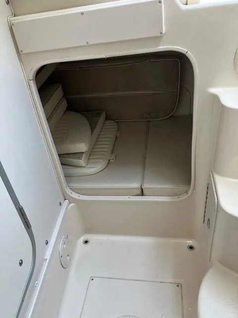 Slide: The Image of 2003 Grady-White Sailfish 282 cabin interior with cushioned seating and storage. - 13