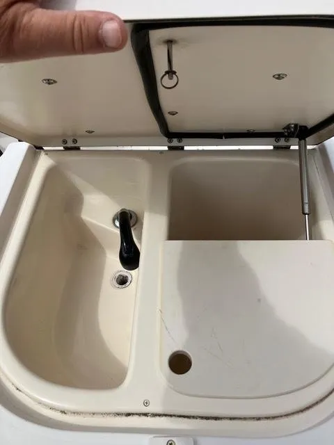 Slide: The Image of 2003 Grady-White Sailfish 282 boat sink with open lid and faucet. - 7