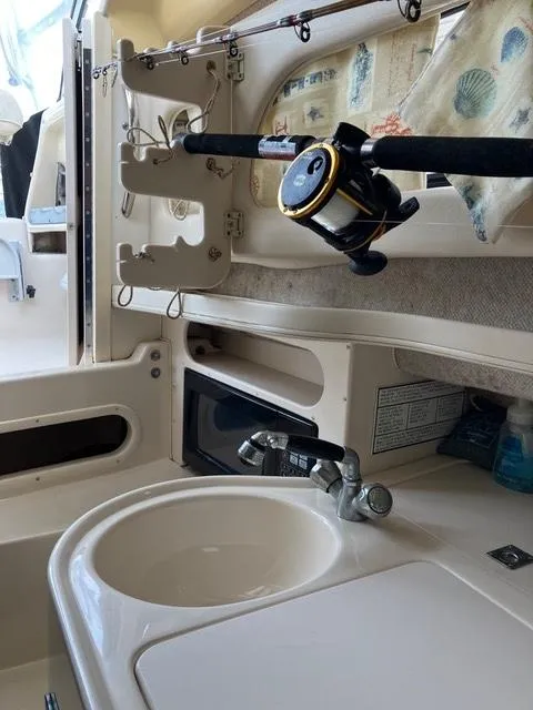 Slide: The Image of 2003 Grady-White Sailfish 282 interior with sink, fishing rod, and microwave. - 9