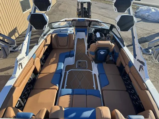 Slide: The Image of 2025 Malibu M230 boat interior with tan and blue seating, advanced audio system, and modern design. - 11