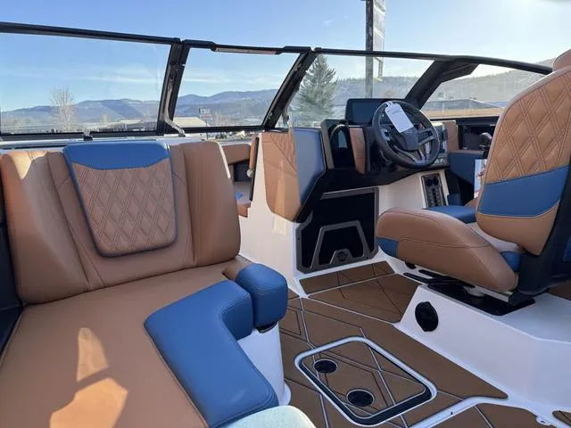 Slide: The Image of Interior of 2025 Malibu M230 boat with luxurious tan and blue seating. - 12