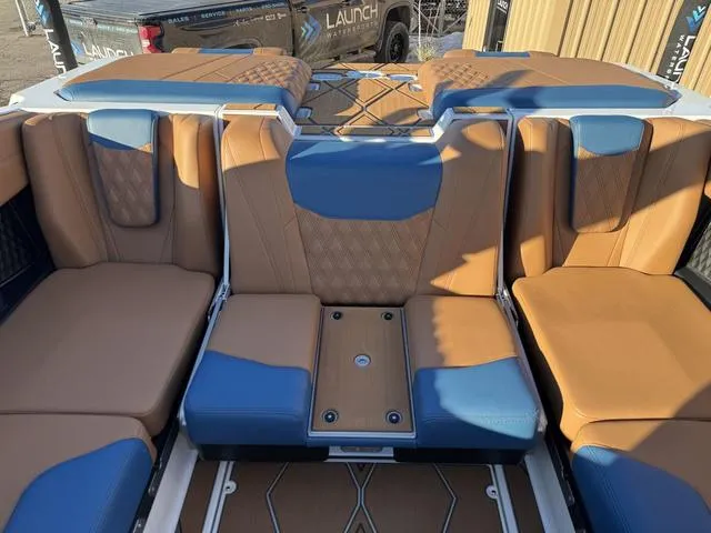 Slide: The Image of 2025 Malibu M230 boat interior with tan and blue seating, showcasing luxury design. - 16
