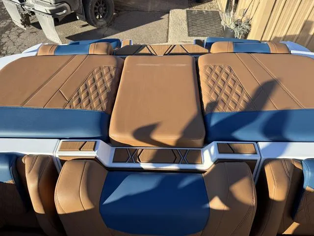 Slide: The Image of 2025 Malibu M230 boat interior with brown and blue leather seats, diamond stitching design. - 17