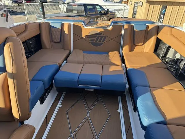 Slide: The Image of Luxurious interior of 2025 Malibu M230 boat with tan and blue seating. - 19