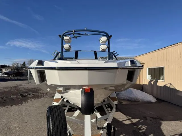 Slide: The Image of 2025 Malibu M230 boat on trailer, front view, clear sky background. - 3