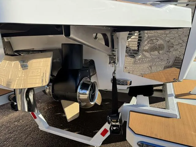 Slide: The Image of 2025 Malibu M230 boat stern with propeller and teak accents. - 9