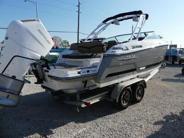 Slide: The Image of 2025 Monterey 255SS boat on trailer with Mercury outboard engine, parked on gravel. - 7