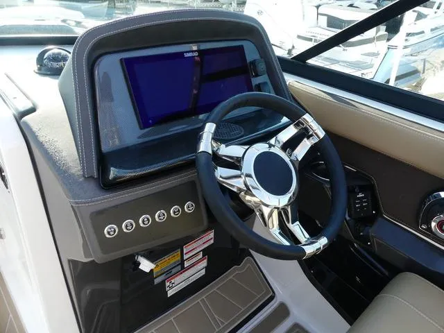 Slide: The Image of 2025 Monterey 255SS boat dashboard with modern steering wheel and digital display. - 9