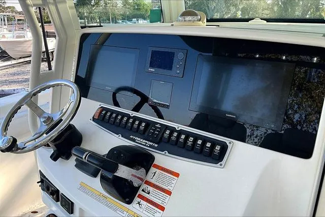 Slide: The Image of 2016 Hydra-Sports 3400 CC boat dashboard with steering wheel and electronic controls. - 11
