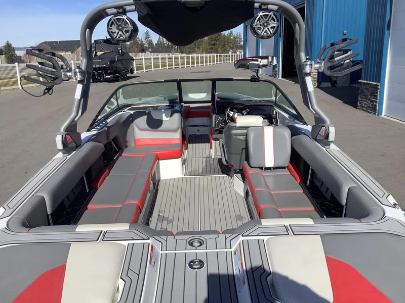 Slide: The Image of 2019 Nautique GS24 boat interior with gray and red seating, open layout, and modern design. - 10