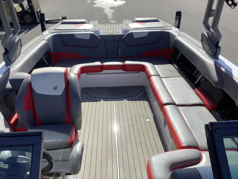 Slide: The Image of 2019 Nautique GS24 boat interior with gray and red seating, spacious layout. - 14