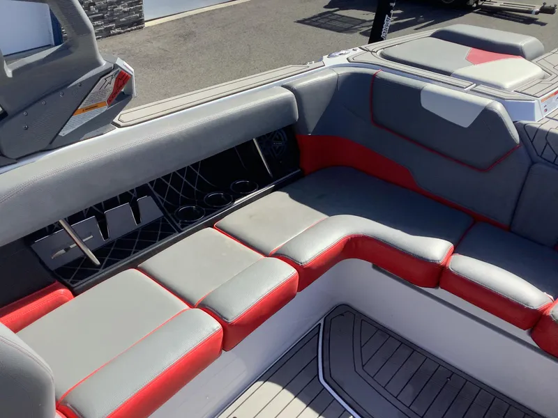 Slide: The Image of 2019 Nautique GS24 boat interior with gray and red seating, cup holders, and sleek design. - 15
