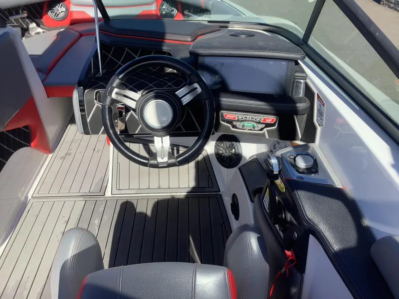 Slide: The Image of 2019 Nautique GS24 boat cockpit with steering wheel and control panel. - 20