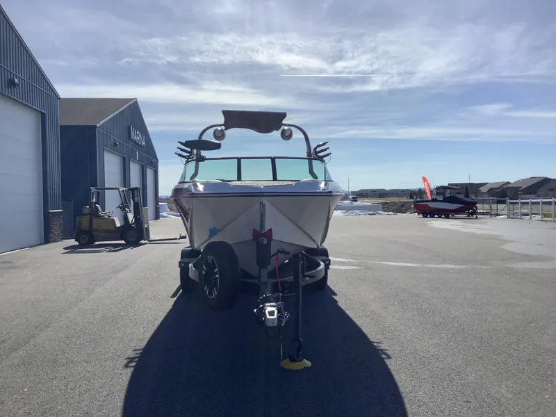 Slide: The Image of 2019 Nautique GS24 boat on trailer at marina under clear sky. - 3