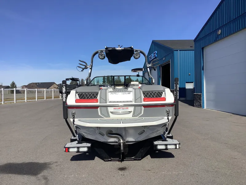 Slide: The Image of 2019 Nautique GS24 boat parked outside a blue building on a sunny day. - 7