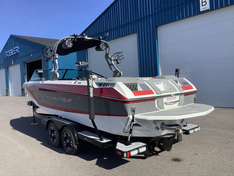 Slide: The Image of 2019 Nautique GS24 boat on trailer outside blue building. - 8