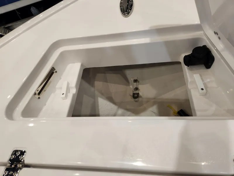 Slide: The Image of 2025 Sportsman Masters 267OE Bay Boat storage compartment, open and empty, showcasing interior details. - 9
