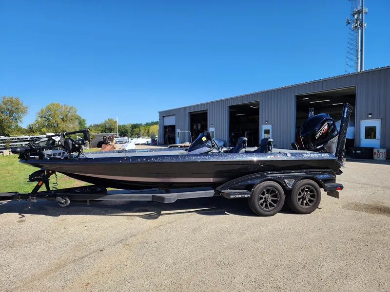 Slide: The Image of 2024 Skeeter FXR21LE boat parked outside a garage on a sunny day. - 1