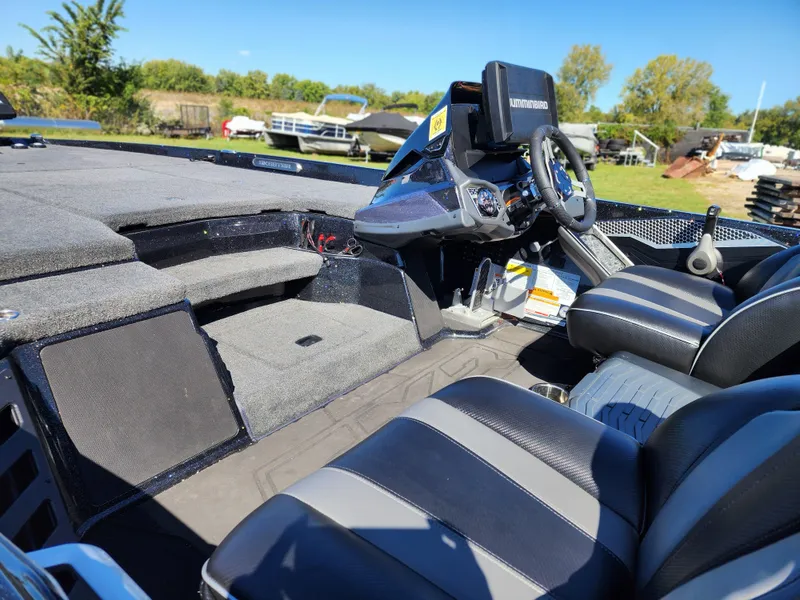 Slide: The Image of 2024 Skeeter FXR21LE boat interior with steering console and seating, outdoors on a sunny day. - 5