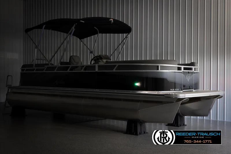 Slide: The Image of 2025 Avalon VLS QL pontoon boat in a showroom with canopy and sleek design. - 4