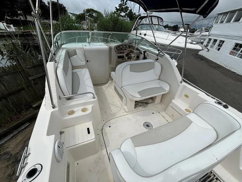 Slide: The Image of 2000 Rinker 242 Fiesta V boat interior with seating and steering wheel. - 4