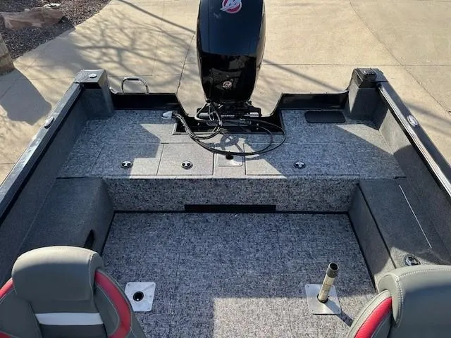 Slide: The Image of 2025 Ranger VS1882SC Angler boat interior with motor, gray carpet, and seating. - 9
