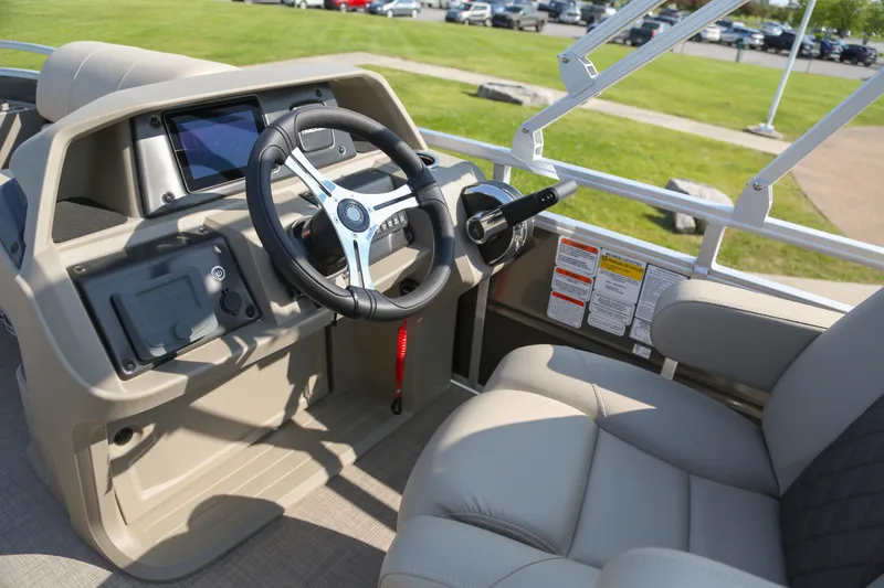 Slide: The Image of 2025 Sun Tracker Fishin' Barge 20 DLX interior with steering wheel and comfortable seating. - 3