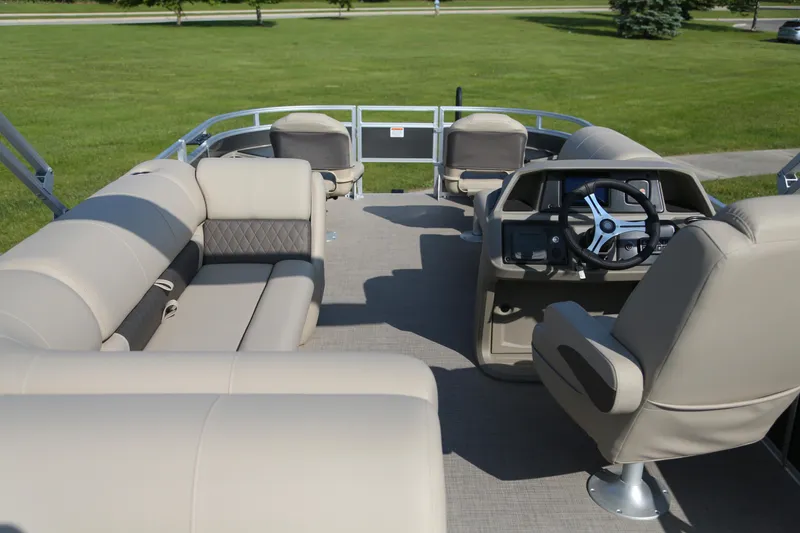 Slide: The Image of 2025 Sun Tracker Fishin' Barge 20 DLX interior with beige seating and steering console. - 5