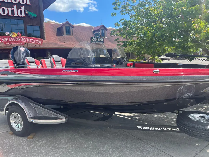 The Image of 2025 Ranger 1880MS boat in red and gray, parked outdoors near a store. - 0