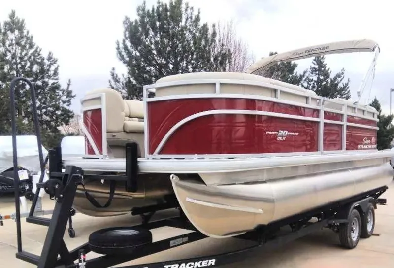 Slide: The Image of 2025 Sun Tracker Party Barge 20 DLX pontoon boat on trailer, red and white design. - 3