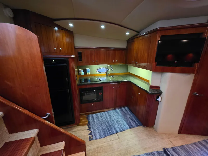 Slide: The Image of Luxurious 2007 Cruisers Yachts 460 Express kitchen with wood cabinetry and modern appliances. - 21