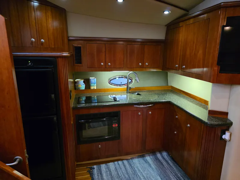 Slide: The Image of Luxurious 2007 Cruisers Yachts 460 Express kitchen with wood cabinetry and modern appliances. - 22