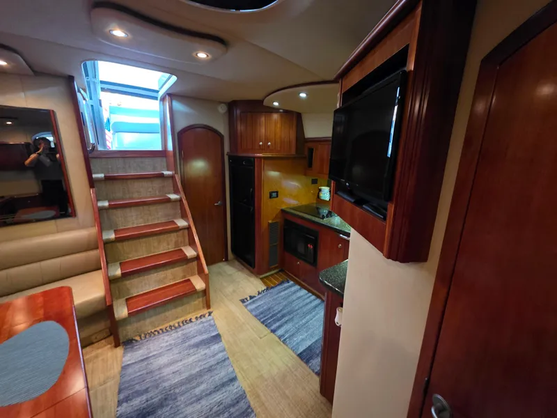 Slide: The Image of Interior of 2007 Cruisers Yachts 460 Express, featuring stairs, kitchen, and seating area. - 24