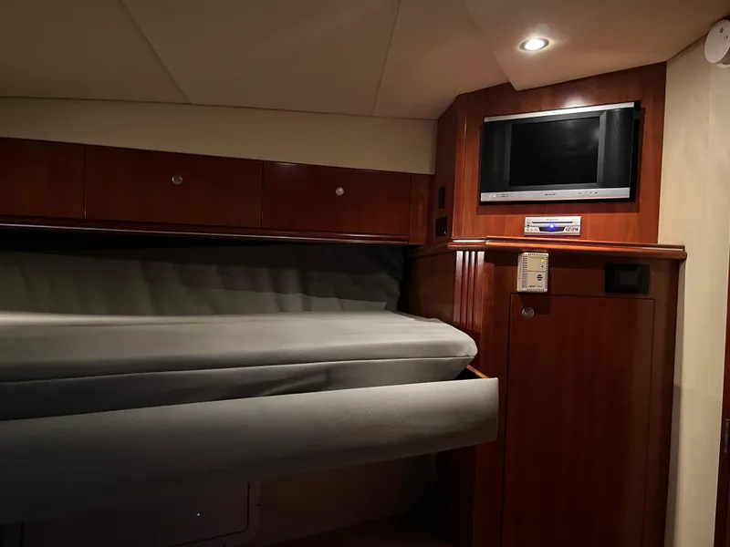 Slide: The Image of 2007 Cruisers Yachts 460 Express cabin interior with TV and wooden cabinetry. - 28