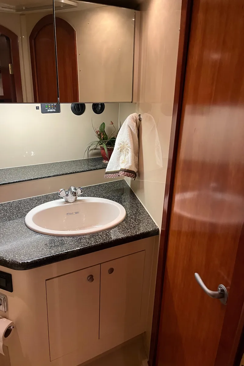 Slide: The Image of 2007 Cruisers Yachts 460 Express bathroom with sink, mirror, and wooden cabinetry. - 32