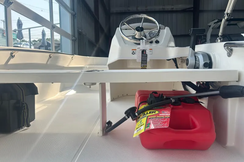 Slide: The Image of 2025 Boston Whaler 130 Super Sport interior with steering wheel and fuel tank. - 6