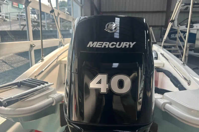 Slide: The Image of 2025 Boston Whaler 130 Super Sport with Mercury 40 HP engine in a showroom. - 7