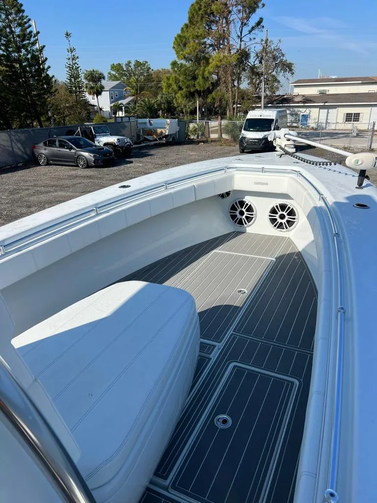 Slide: The Image of 2023 Contender 35ST boat with spacious deck and modern design, parked outdoors. - 7