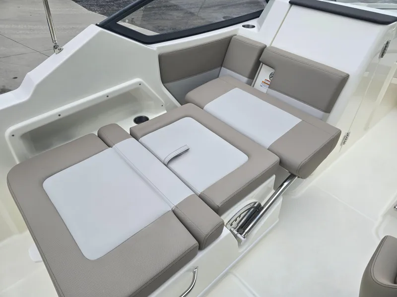 Slide: The Image of 2025 Boston Whaler 210 Vantage boat interior with beige and white cushioned seating. - 13