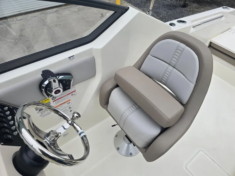 Slide: The Image of 2025 Boston Whaler 210 Vantage helm with steering wheel and cushioned seat. - 22