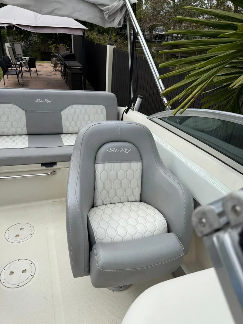 Slide: The Image of 2010 Sea Ray 220 Sundeck interior with gray and white seating, outdoor setting. - 6