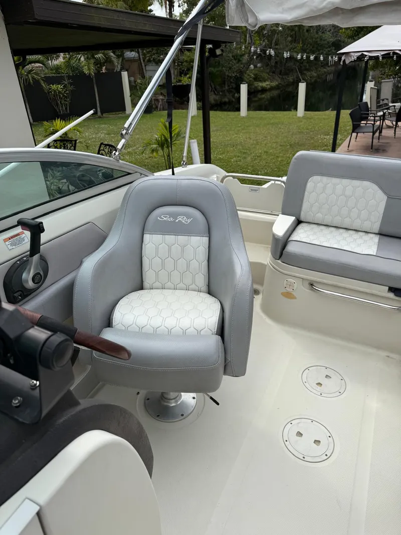 Slide: The Image of 2010 Sea Ray 220 Sundeck boat interior with gray and white seating. - 7