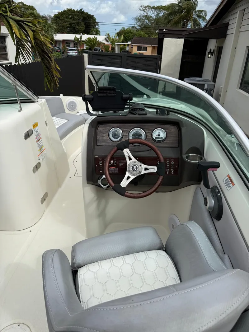 Slide: The Image of 2010 Sea Ray 220 Sundeck boat interior with steering wheel and dashboard controls. - 9