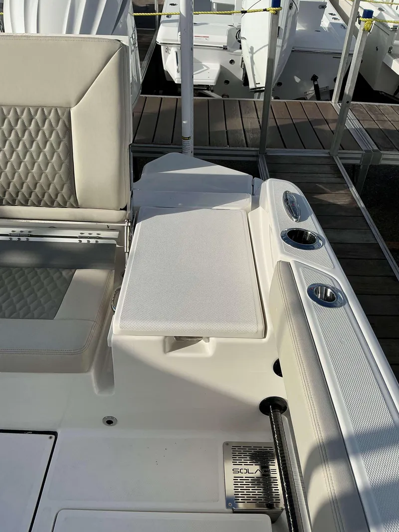 Slide: The Image of 2025 Solace 28 HCS boat interior with cushioned seating and cup holders. - 11