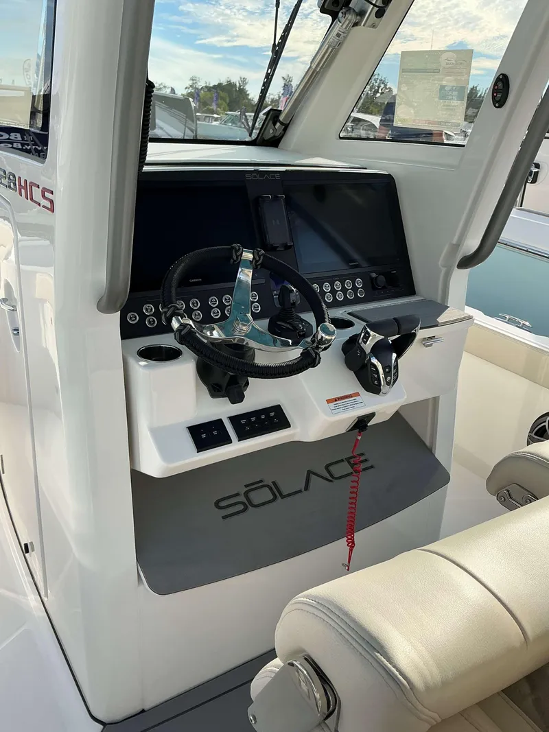 Slide: The Image of 2025 Solace 28 HCS boat dashboard with steering wheel and control panel. - 17